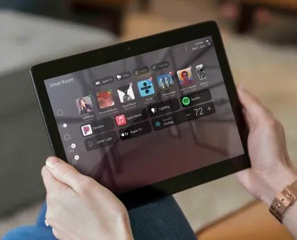 A tablet displaying the Control4 app interface with named scenes and rooms